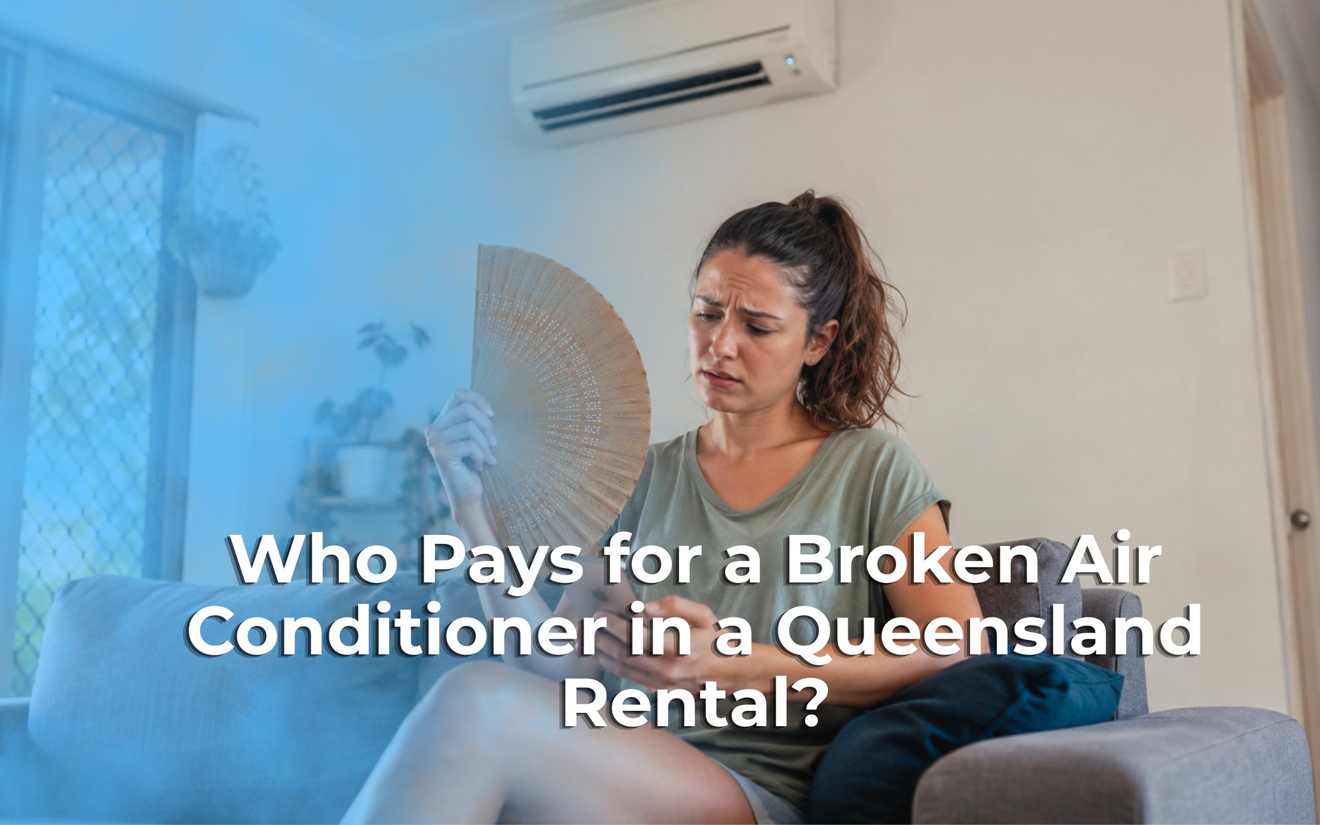 Woman sits on a couch fanning herself indoors, looking worried.
